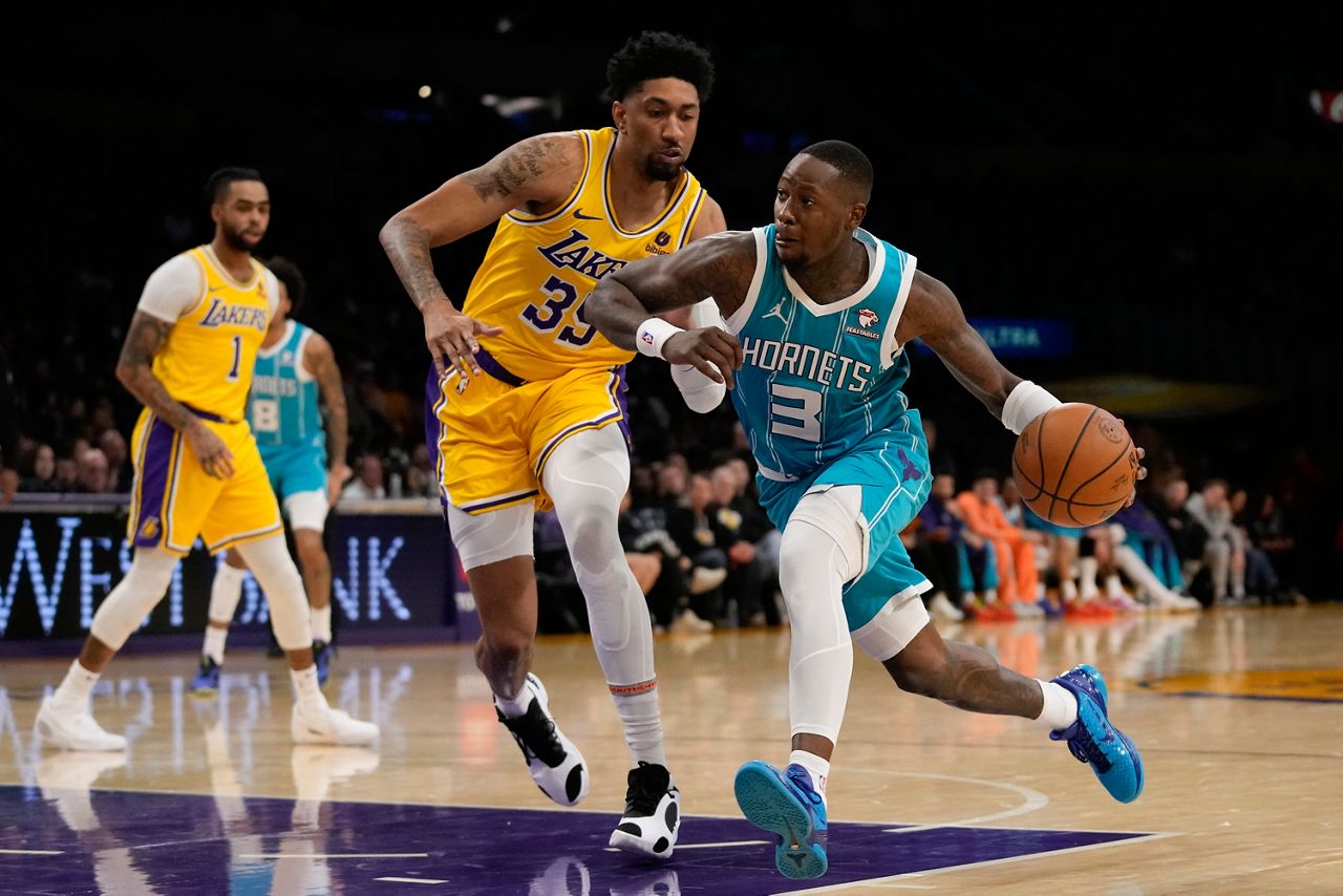 Los Angeles Lakers forward Christian Wood (35) defends against Charlotte Hornets guard Terry Rozier (3) during the first half of an NBA basketball game in Los Angeles, Thursday, Dec. 28, 2023. (AP Photo/Ashley Landis)